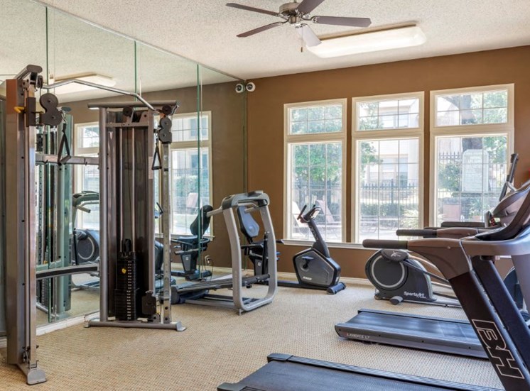 Fitness Center with Exercise Equipment and Mirror Accent Wall